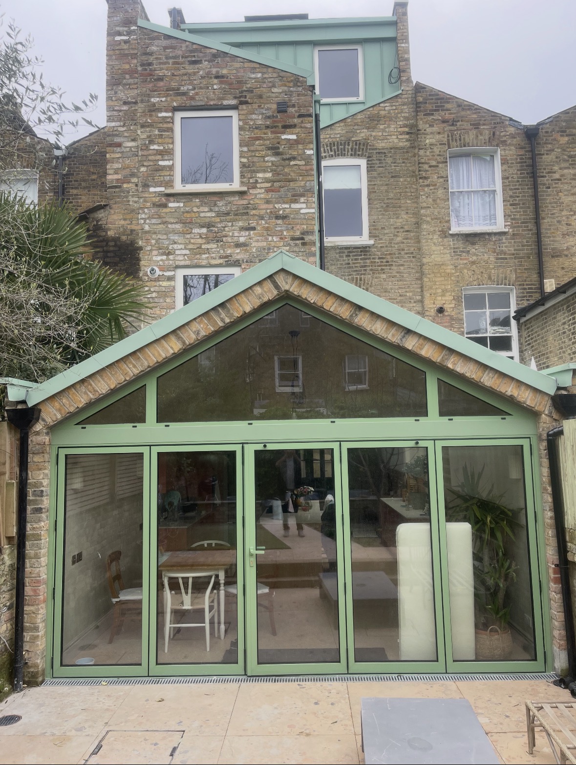 Rear glazed gable extension with sage green frames and bifold doors
