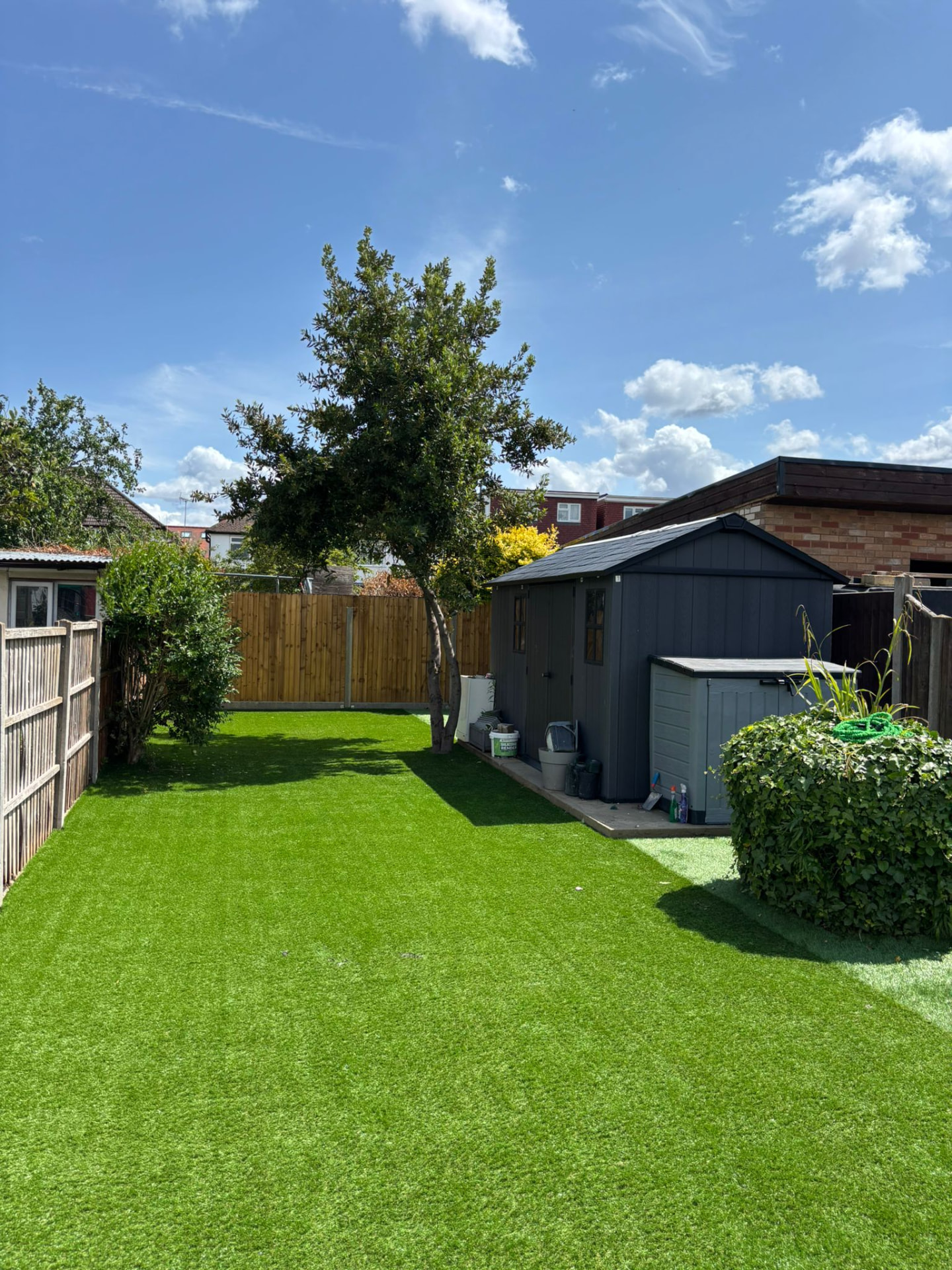 Landscaped rear garden with artificial lawn, new fencing and garden store